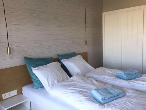 Cette chambre comprend 2 lits avec des draps blancs et des oreillers bleus. dans l'établissement Wellington F7, à La Panne