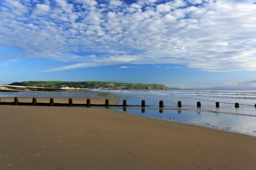 a beach with a view of the ocean and a pier at Llety Ceiro Guesthouse in Aberystwyth
