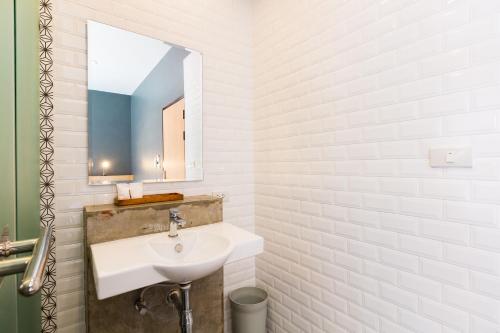 a white bathroom with a sink and a mirror at Srisuksant Square in Krabi town