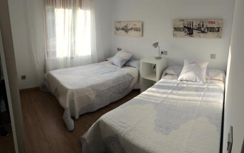 カルデスにあるLos Pinos de Cardesのベッドルーム1室(ベッド2台、窓付)