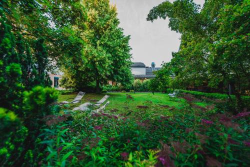 a park with benches in the grass and trees at Bildungshaus St. Hippolyt in Sankt Pölten