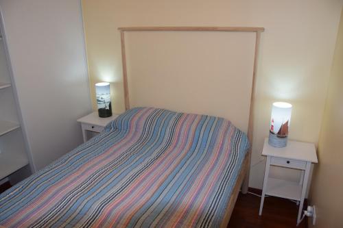 um pequeno quarto com uma cama e duas mesas de cabeceira em les terrasses de Dahouet em Pléneuf-Val-André