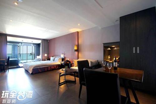 a hotel room with a bed and a table and chairs at Jing Guan Hotel in Eluan