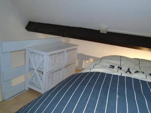 ヴズールにあるAppartement BellesRivesのベッドルーム(青いベッド1台、白いキャビネット付)