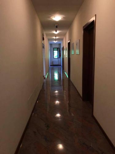 an empty hallway with a long hall with lights on it at Hotel Ristorante Gallo D'Oro in Vignola