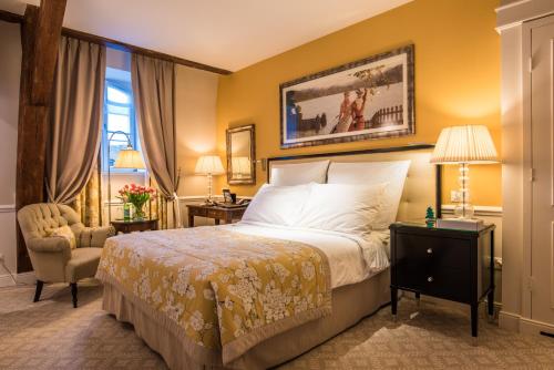 a hotel room with a bed and a chair at Grand Hotel du Lac - Relais & Châteaux in Vevey