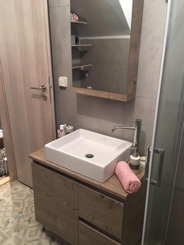 a bathroom with a white sink and a mirror at Leo's city apartment in Lefkada