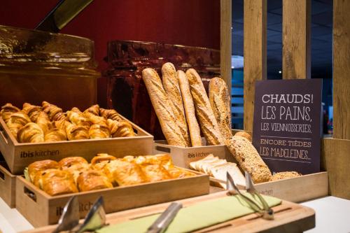 a display of bread and pastries in boxes on a table at ibis Amsterdam City West in Amsterdam