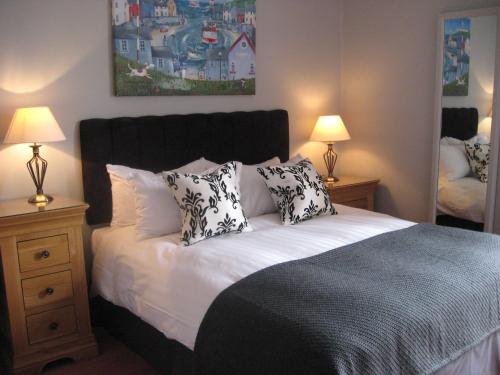 a bedroom with a bed with black and white pillows at Shaftesbury Hotel Dundee in Dundee