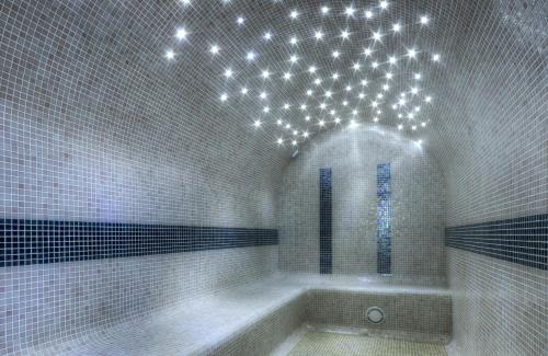 a bathroom with a tub with lights on the ceiling at Hotel Puerto Bahía & Spa in El Puerto de Santa María