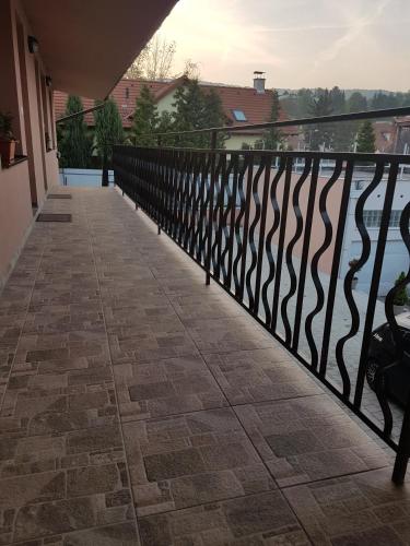 a balcony with a black railing and a view of the water at Apartmány Malý Princ in Bojnice