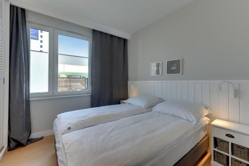 a bedroom with two beds and a window at INA Rent - Tre Mare Apartamenty in Gdańsk