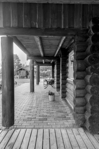 a porch of a log cabin with a bench on it at Tuisuliiva Holiday House in Kabli