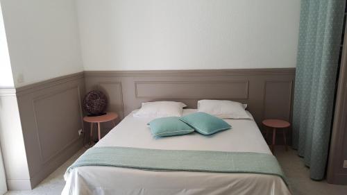 a bed with two pillows on top of it at L'Appart d'en face Casa Cosy in Le Pouliguen