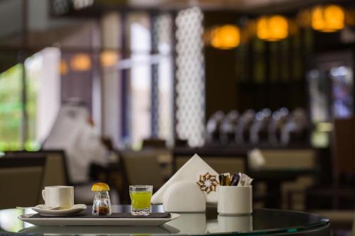 a table with a tray with cups and drinks on it at Ayla Grand Hotel in Al Ain