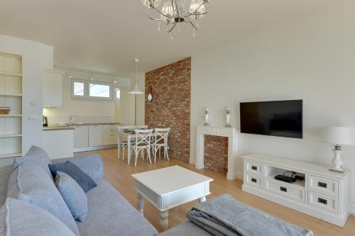 a living room with a couch and a table at INA Rent - Tre Mare Apartamenty in Gdańsk