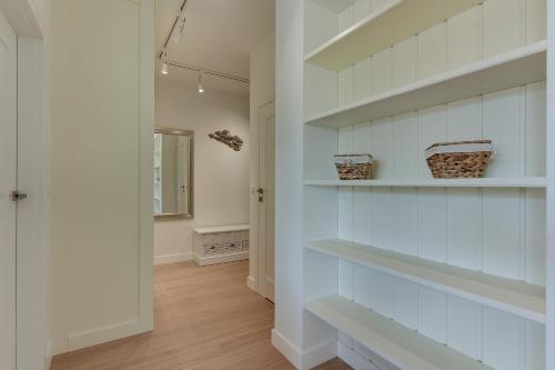 a hallway with white shelves in a house at INA Rent - Tre Mare Apartamenty in Gdańsk