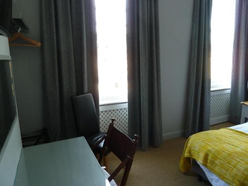 a hotel room with a desk and a bed and window at Edgar Townhouse in Bath