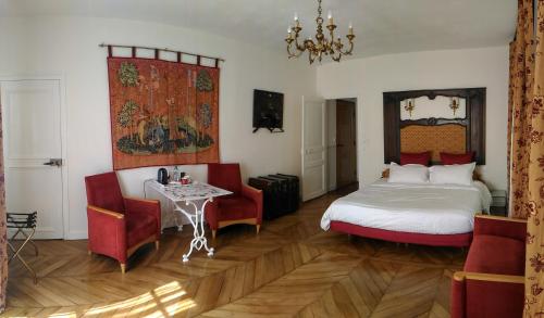 サン・マルセルにあるLe Jardin Des Erablesのベッドルーム1室(ベッド1台、テーブル、椅子付)