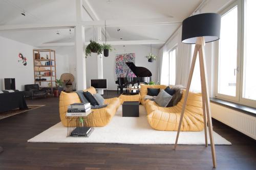 a living room with two couches and a table at Weimar Central Artist Loft - 120 m2 in Weimar