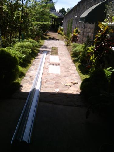 a garden path with a pool in a yard at Rakai Garung in Yogyakarta