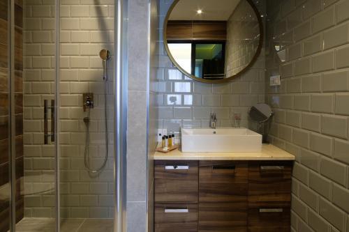 W łazience znajduje się umywalka i lustro. w obiekcie SL Industry Hotel w mieście Trebinje