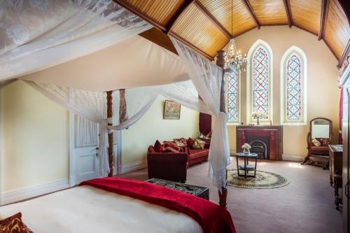 ein Schlafzimmer mit einem Himmelbett und ein Wohnzimmer in der Unterkunft Abbey Boutique Hotel Adults only in Warwick
