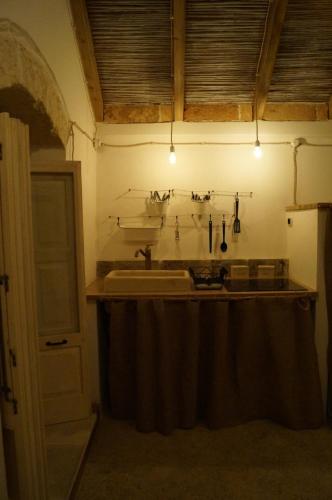 una cucina con lavandino e bancone con luci di la chiesetta a Nardò