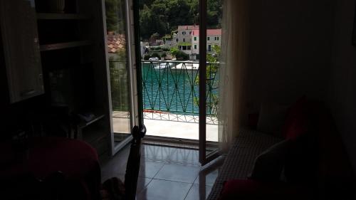 a room with a view of a swimming pool through a sliding glass door at Apartment Antica in Povlja