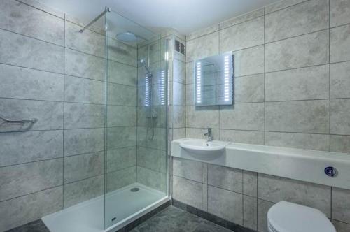 y baño con ducha, lavabo y aseo. en Hotel Jerbourg en St. Peter Port