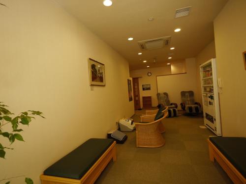 a room with a waiting room with tables and chairs at Hotel Route-Inn Tokoname Ekimae in Tokoname