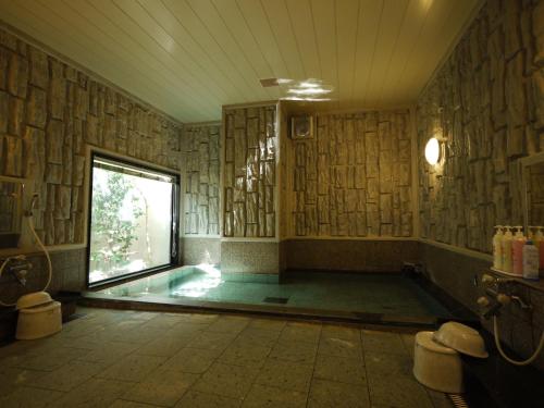 a bathroom with a swimming pool with a window at Hotel Route-Inn Tokoname Ekimae in Tokoname