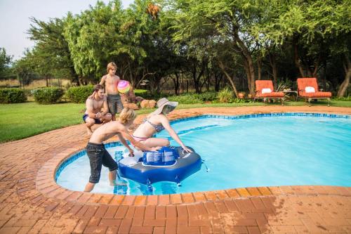 a group of people playing in a swimming pool at Boubou Bed and Breakfast in Rustenburg