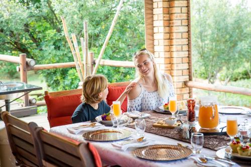 a woman and a child sitting at a table at Boubou Bed and Breakfast in Rustenburg