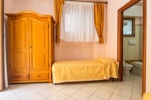 a bathroom with a bed and a cabinet and a toilet at Hotel San Francisco in Cala Gonone