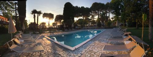 a swimming pool with lounge chairs and a resort at Hotel Sirena in Lazise