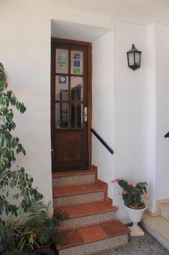 a wooden door in a white building with stairs at La Posada de Mijas in Mijas