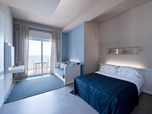 a bedroom with a bed and a large window at Il Fogliano Hotel New Life in Latina