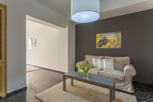 a living room with a couch and a table at Tranquil Central Apt, behind Athens Caravel Area in Athens