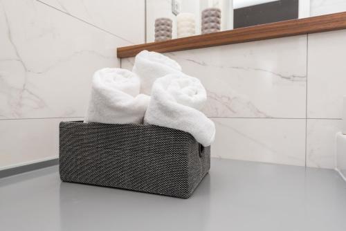 a basket of towels sitting on a counter in a bathroom at Sunset Beach Apartment in Zadar