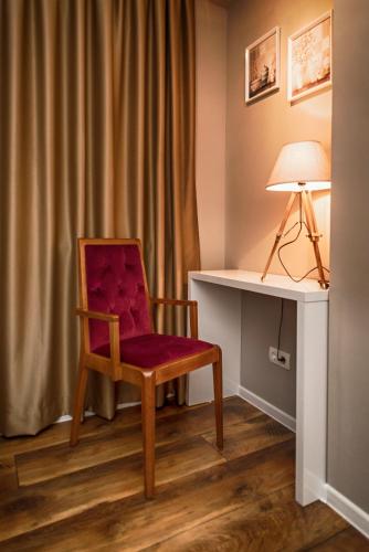 a red chair sitting in front of a desk at Luxury Studio Yasmine in Mostar