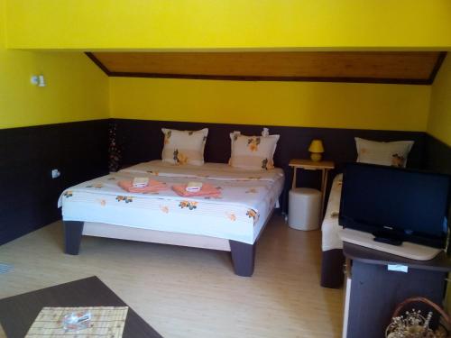 a bedroom with a bed and a flat screen tv at Guesthouse Geto in Belogradchik