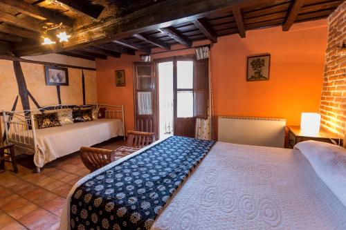 San Esteban de la Sierraにあるcasa rural la tramoneraのオレンジ色の壁のベッドルーム1室(ベッド1台付)