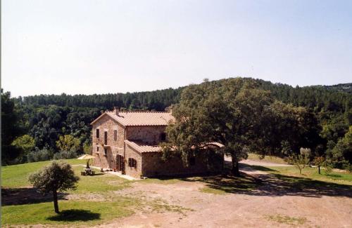 uma casa velha no meio de um campo em Agriturismo Poggio Macinaio em Roccastrada