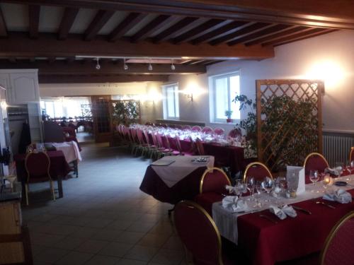 une salle à manger avec des tables, des chaises et des verres à vin dans l'établissement Le Clos Fleuri, à Bourg-de-Thizy