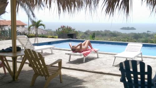 a woman laying on a chair next to a swimming pool at El Mirador Ecológico, Ometepe in Altagracia
