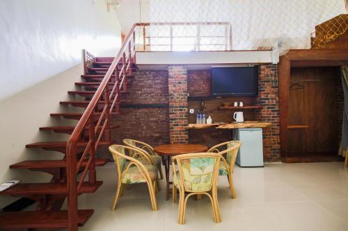 a dining room with a table and chairs and a staircase at Kiln B&B in Fuli