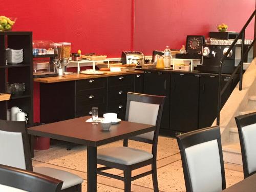 a kitchen with a table and chairs and a counter at Hotel De L'Europe in Toul