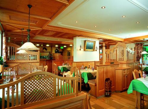 un ristorante con tavoli e sedie in legno di Theresenhof a Reit im Winkl