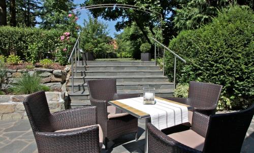 a patio with a table and chairs and stairs at Waldhotel Bad Soden in Bad Soden am Taunus